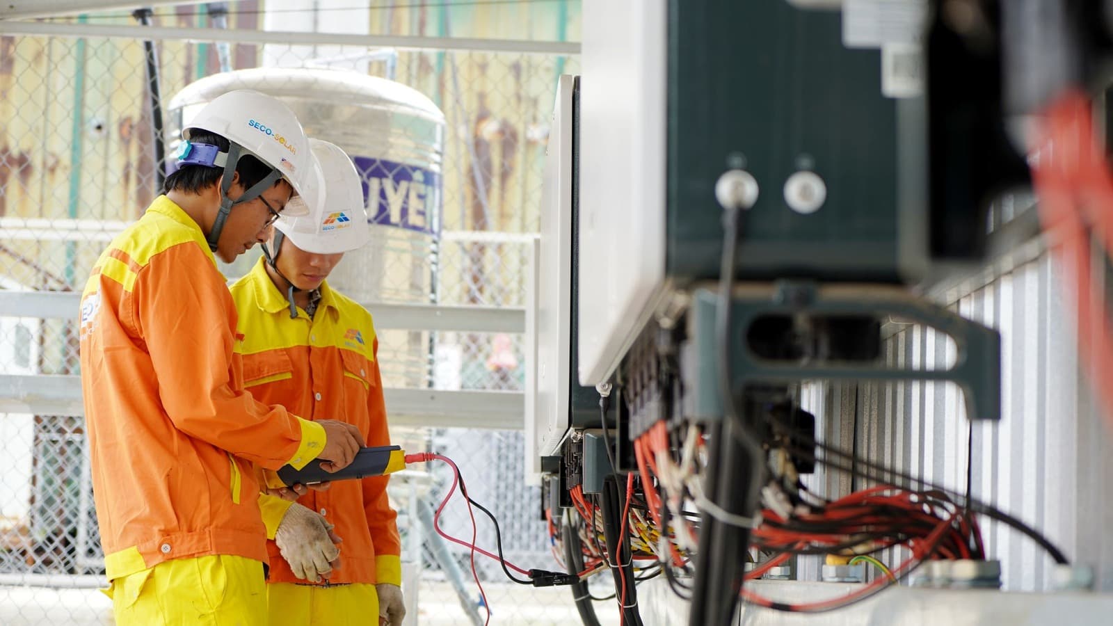 Twee elektromonteurs gebruiken meetapparatuur bij een elektrische installatie