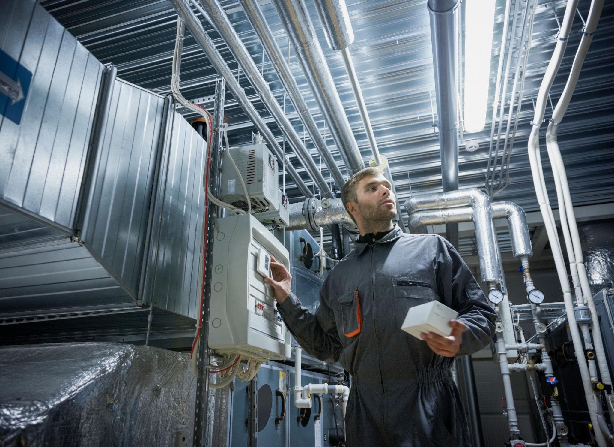 Technicus controleert installaties en leidingen in een technische ruimte